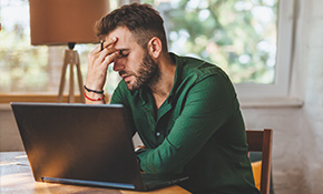 image of frustrated man using a laptop